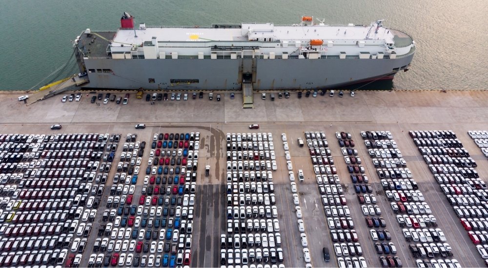 Vehicles are shown near a cargo ship.